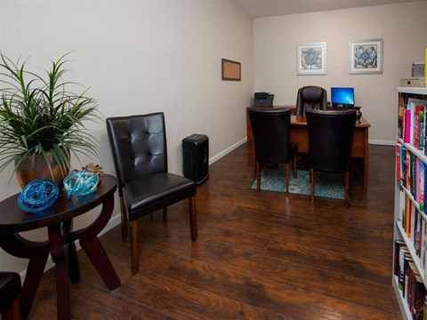 a living room with a table and chairs and a library