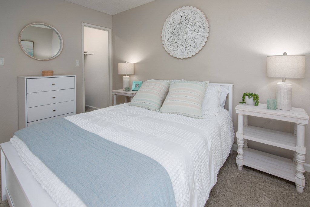 Model apartment spare bedroom with a bed and two night stands at Willow Grove Apartments, California
