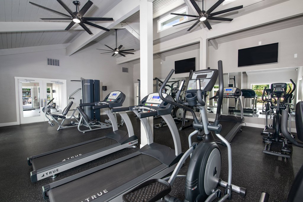 Fitness center with cardio equipment and televisions at Rivercrest Apartments, California, 95826