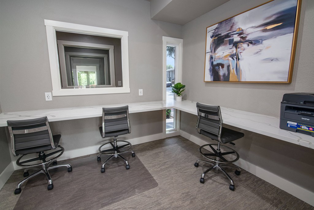 Resident business center with two chairs and a desk and a window at Rivercrest Apartments, Sacramento California 