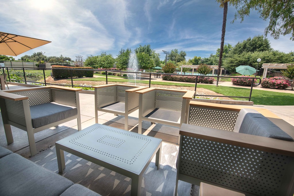 A patio area with tables and chairs and a fountain at Rivercrest Apartments, Sacramento, CA 