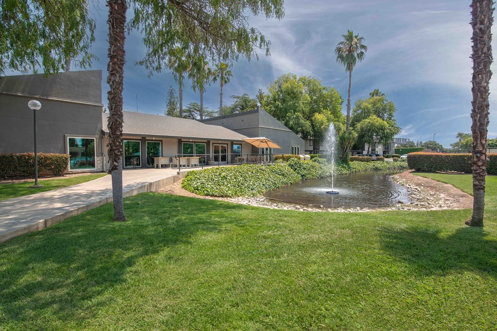 A fountain in front of the leasing office and palm trees at Rivercrest Apartments, Sacramento, 95826 