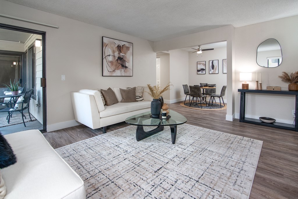 Model Apartment living room with a white couch and a glass coffee table at Rivercrest Apartments, Sacramento, CA 95826