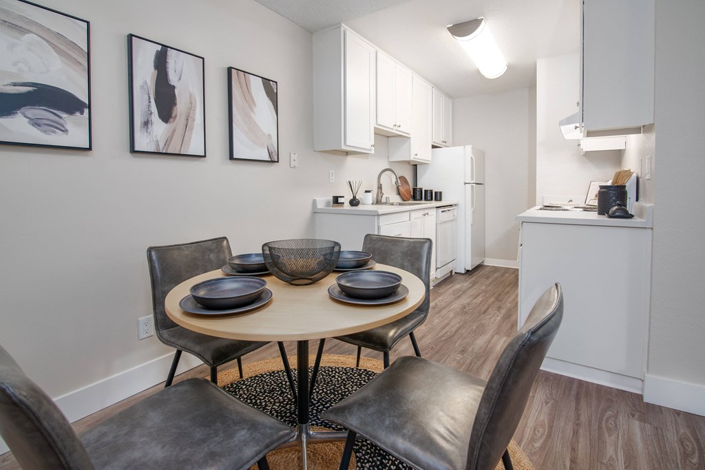 Model Apartment dining room with a table and chairs and a kitchen at Rivercrest Apartments, Sacramento 