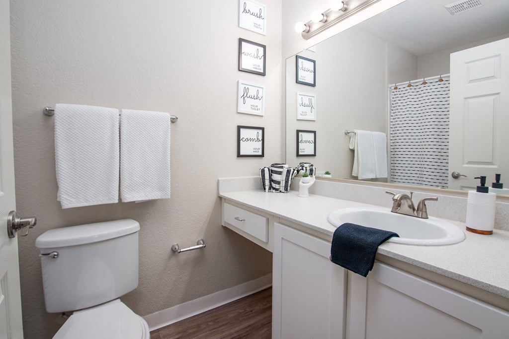 Model apartment spare bathroom with a sink and a toilet and a mirror at Rivercrest Apartments, Sacramento, CA 95826 