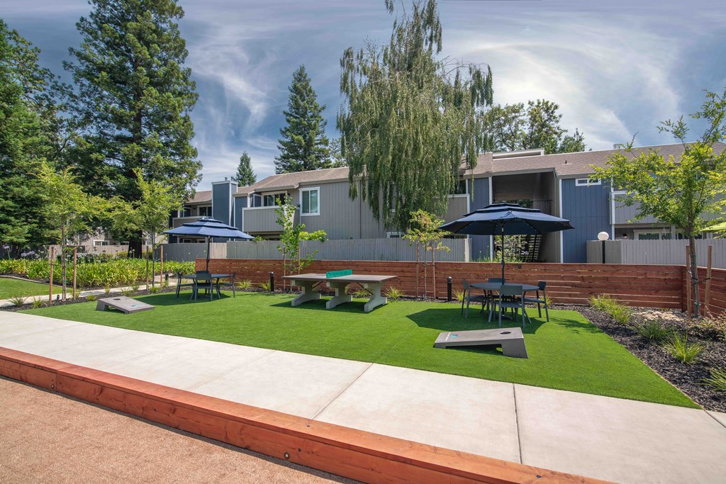 Resident courtyard with outdoor games and furniture at Willow Grove Apartments, Sacramento, CA 