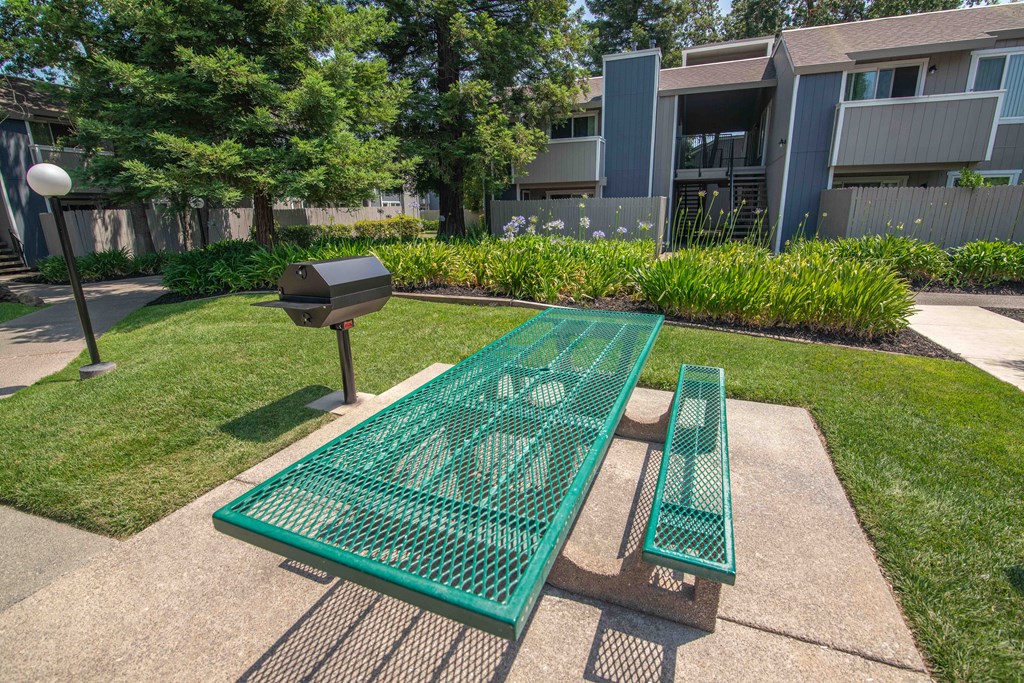 BBQ and Picnic table and benches in front of an apartment building at Willow Grove Apartments, Sacramento 
