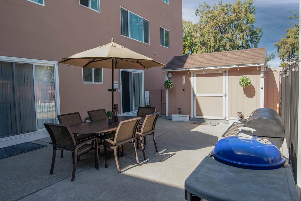 BBQ patio with a table and chairs and a grill