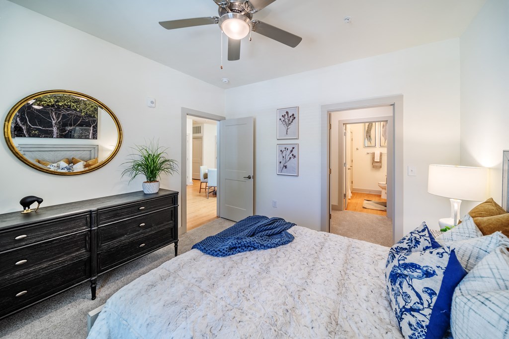a bedroom with a large bed and a ceiling fan