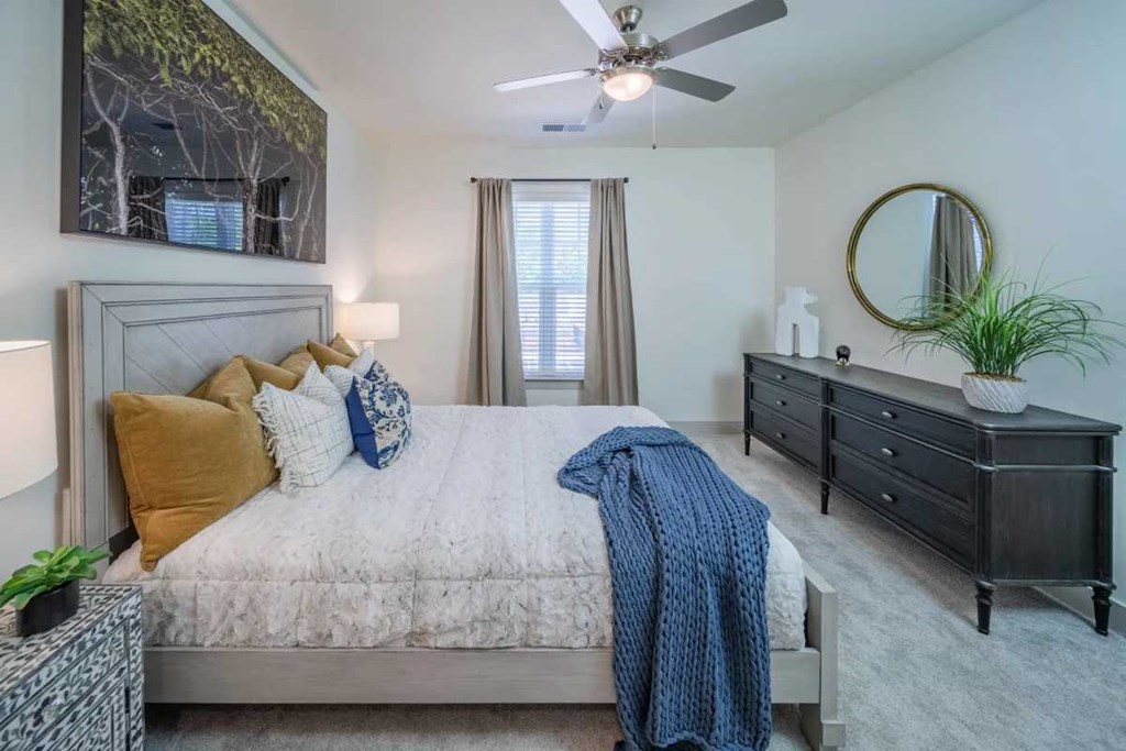 a bedroom with a bed and a ceiling fan