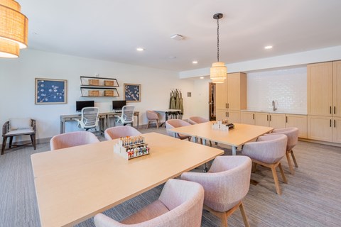 a dining room with tables and chairs and a kitchen