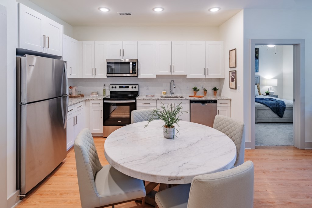 a kitchen with stainless steel appliances and a marble dining table