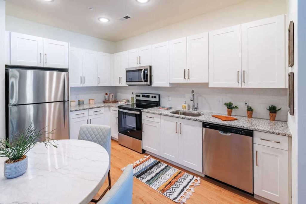 a kitchen with stainless steel appliances and white cabinets