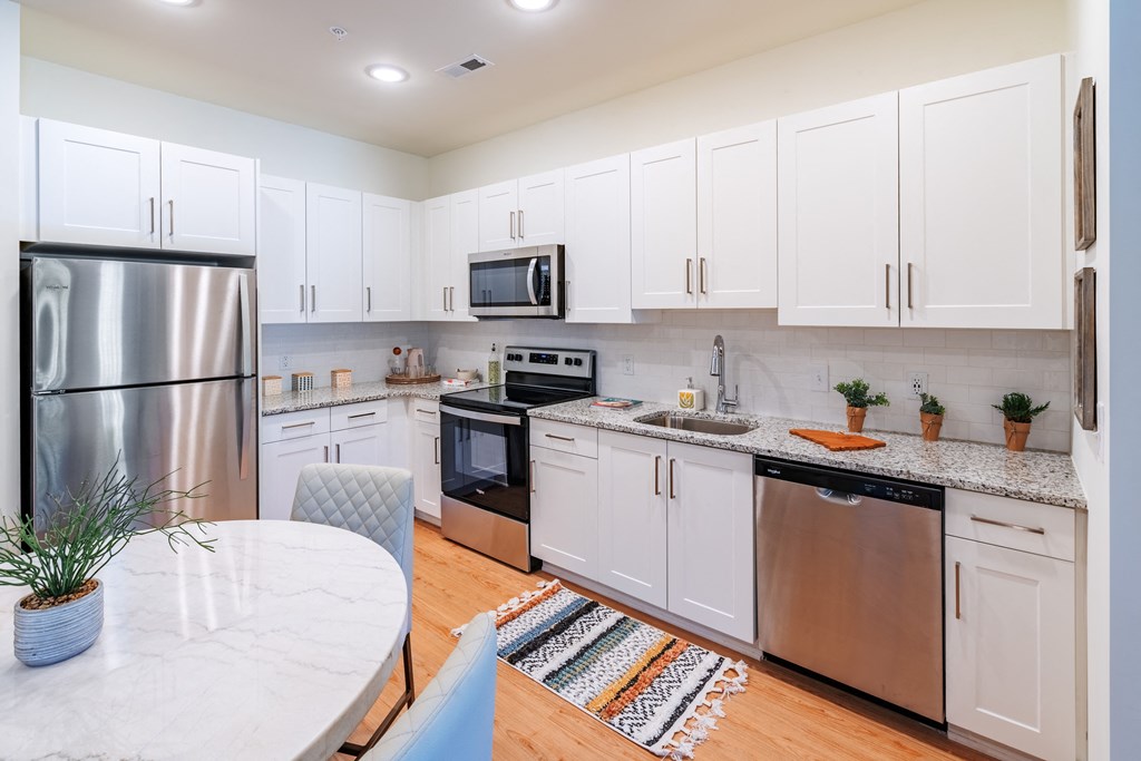 a kitchen with stainless steel appliances and white cabinets