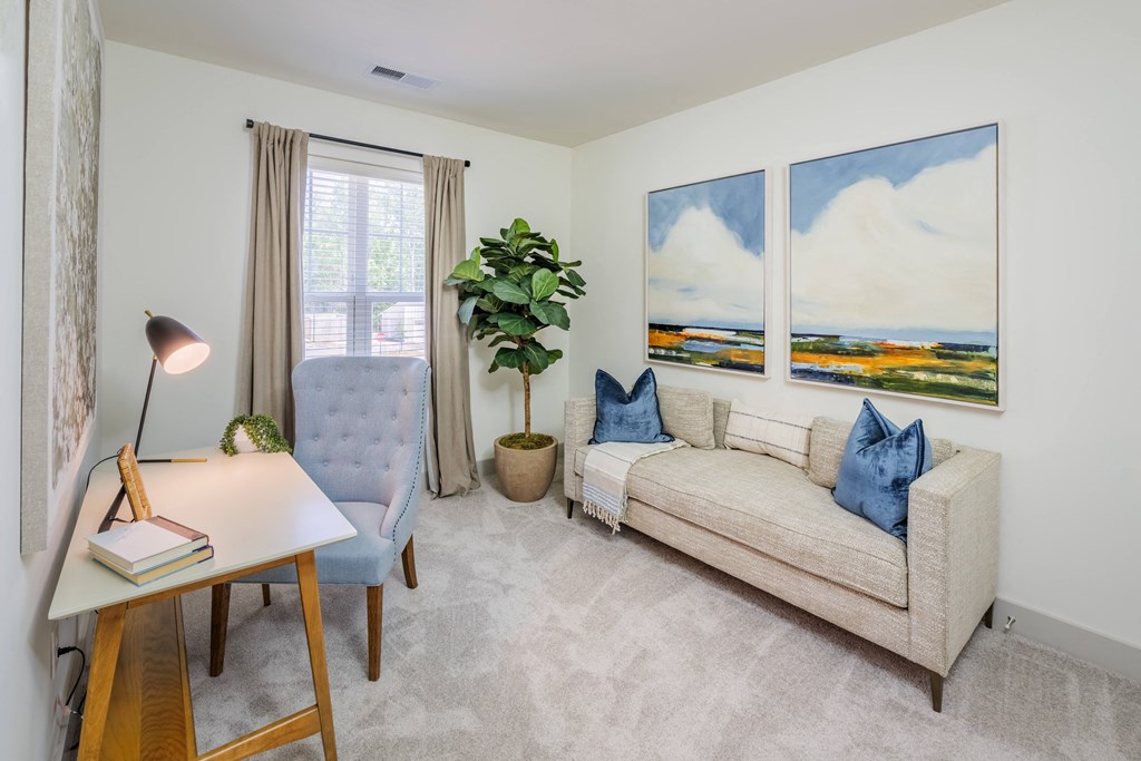 a living room with a couch and a chair and a desk