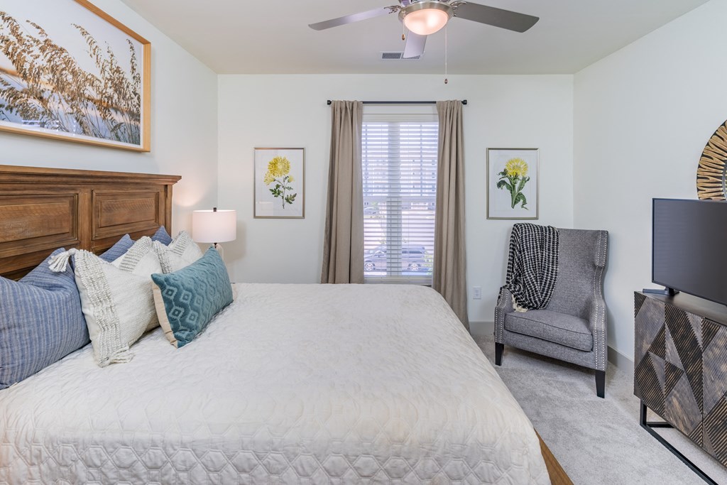 a bedroom with a large bed and a ceiling fan