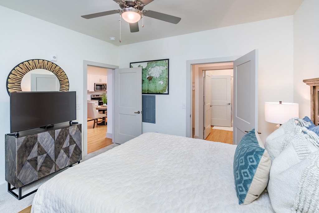 a bedroom with a large bed and a ceiling fan