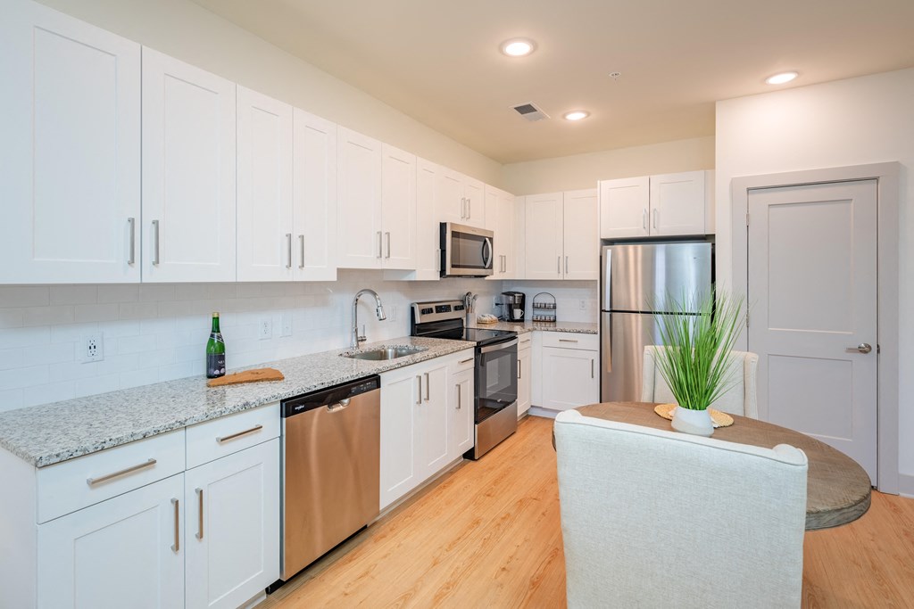 a kitchen with white cabinets and stainless steel appliances