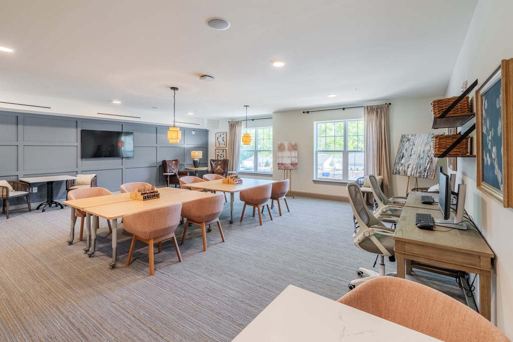 a dining room with tables and chairs and a living room with a television