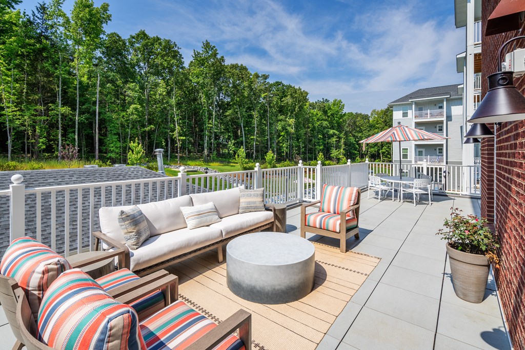 a large deck with couches and chairs and a table