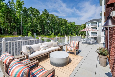 a large deck with couches and chairs and a table