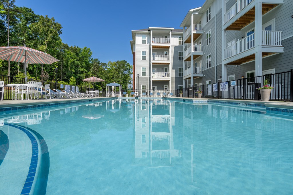 a swimming pool with an apartment building in the background