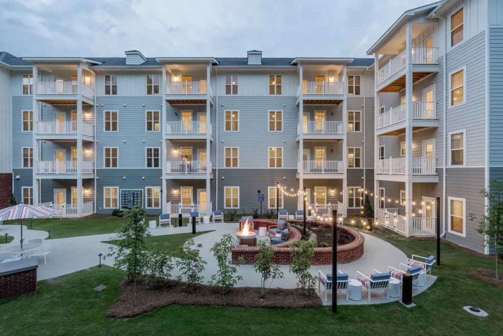 an exterior view of an apartment building with a fountain