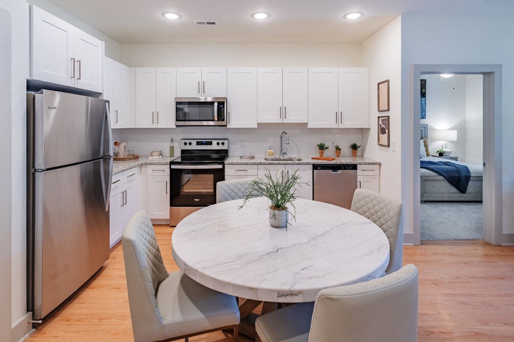a kitchen and dining room with stainless steel appliances and a marble table