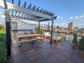 a rooftop deck with a picnic table and a view of the city