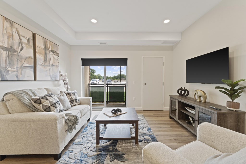 A living room with a white couch, a coffee table, and a large painting on the wall.