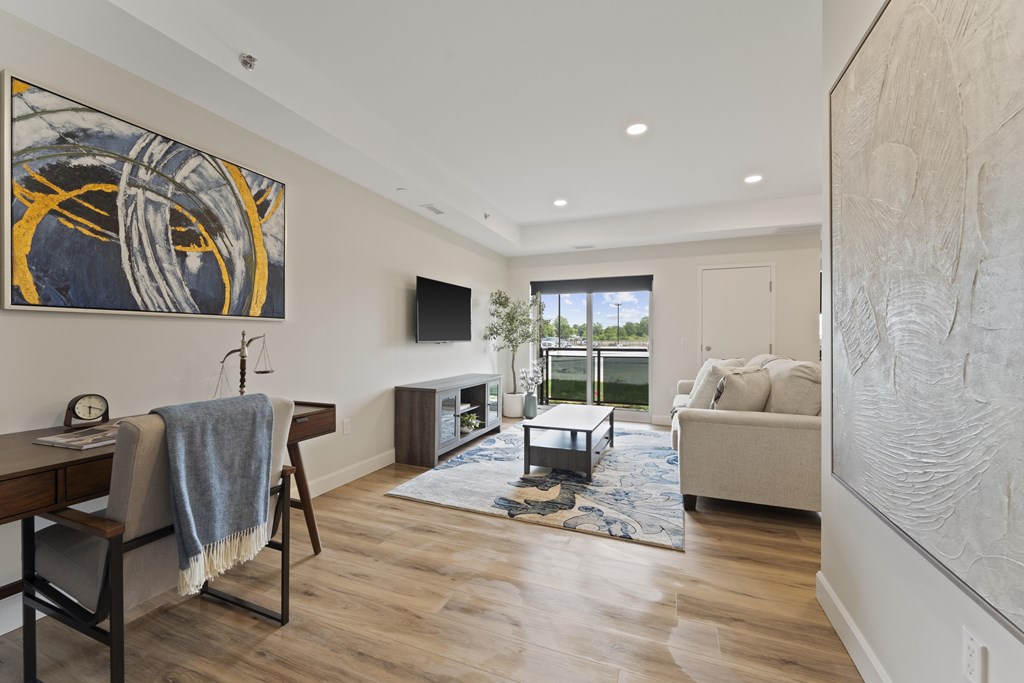 A living room with a couch, a chair, a coffee table, and a painting on the wall.