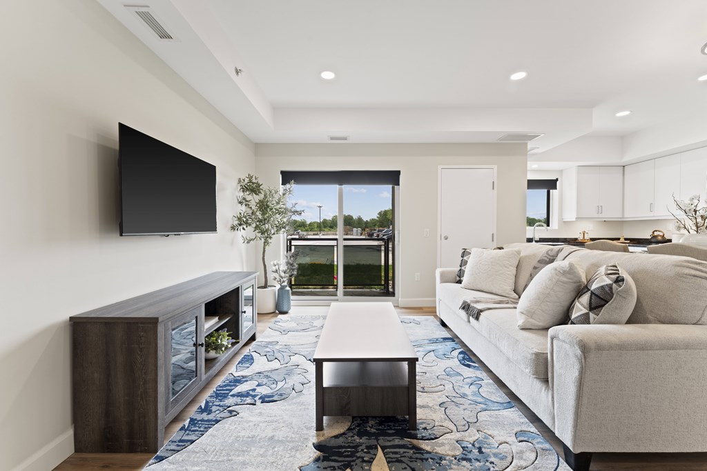 A modern living room with a flat screen TV mounted on the wall.