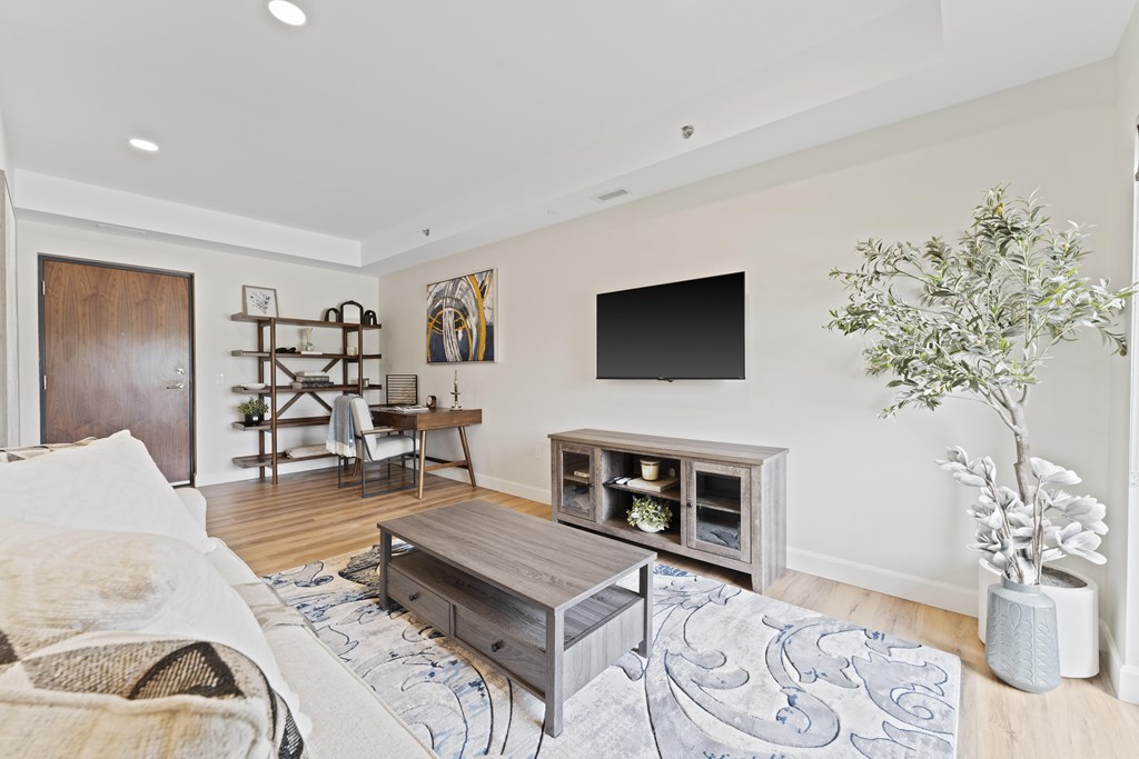 A living room with a white couch and a wooden coffee table.