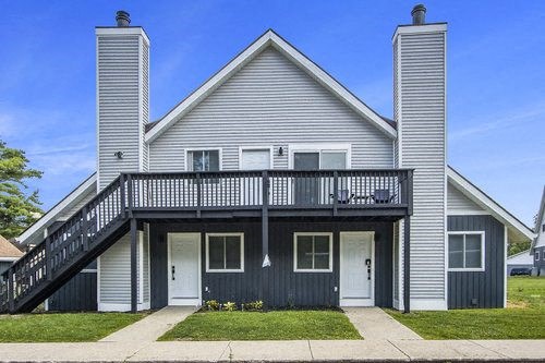 a gray house with a balcony on a