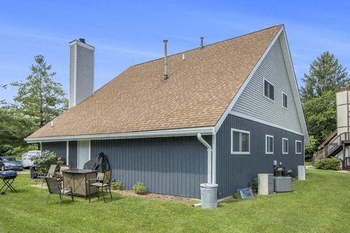 a blue house with a table and chairs in the yard