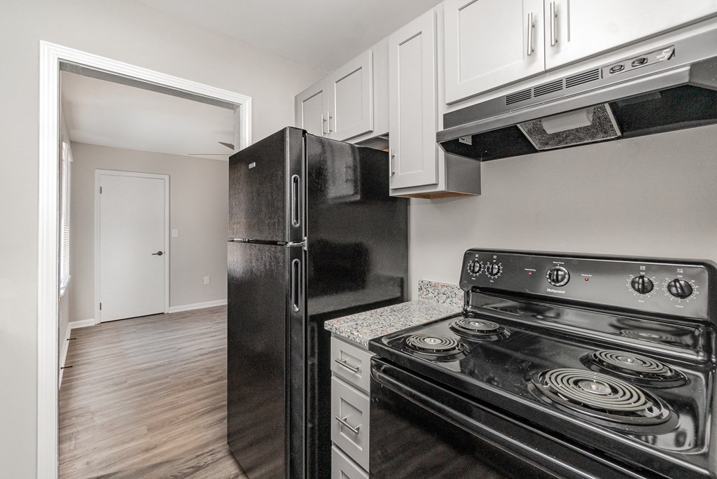 a kitchen with black appliances and white cabinets