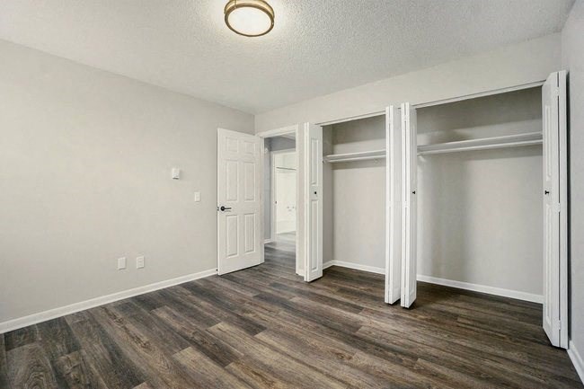 an empty living room with a door to a closet