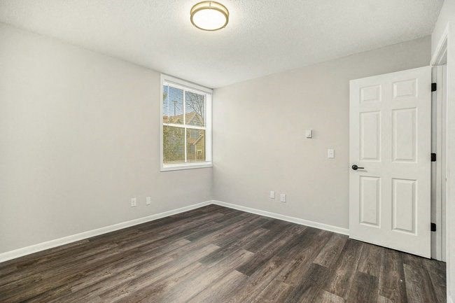 an empty bedroom with a door and a window