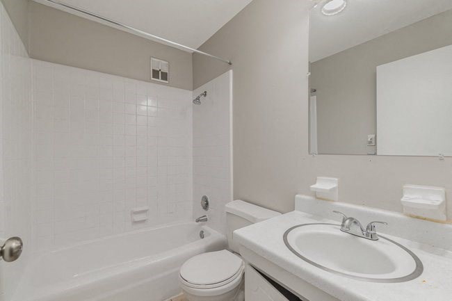 a white bathroom with a sink and a bath tub