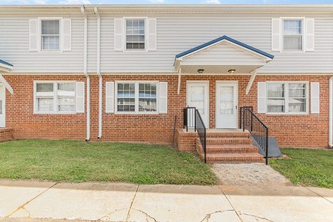 a white house with steps and a yard in front of it