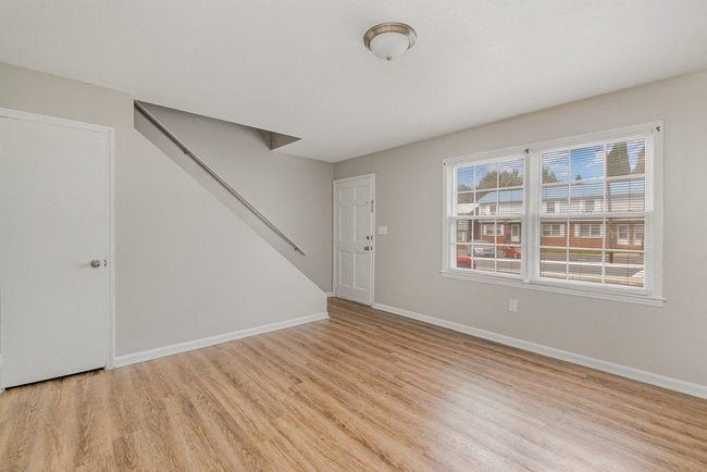 an empty living room with a door and a window