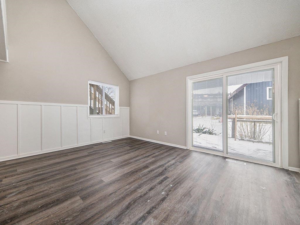 an empty living room with a sliding glass door to a patio