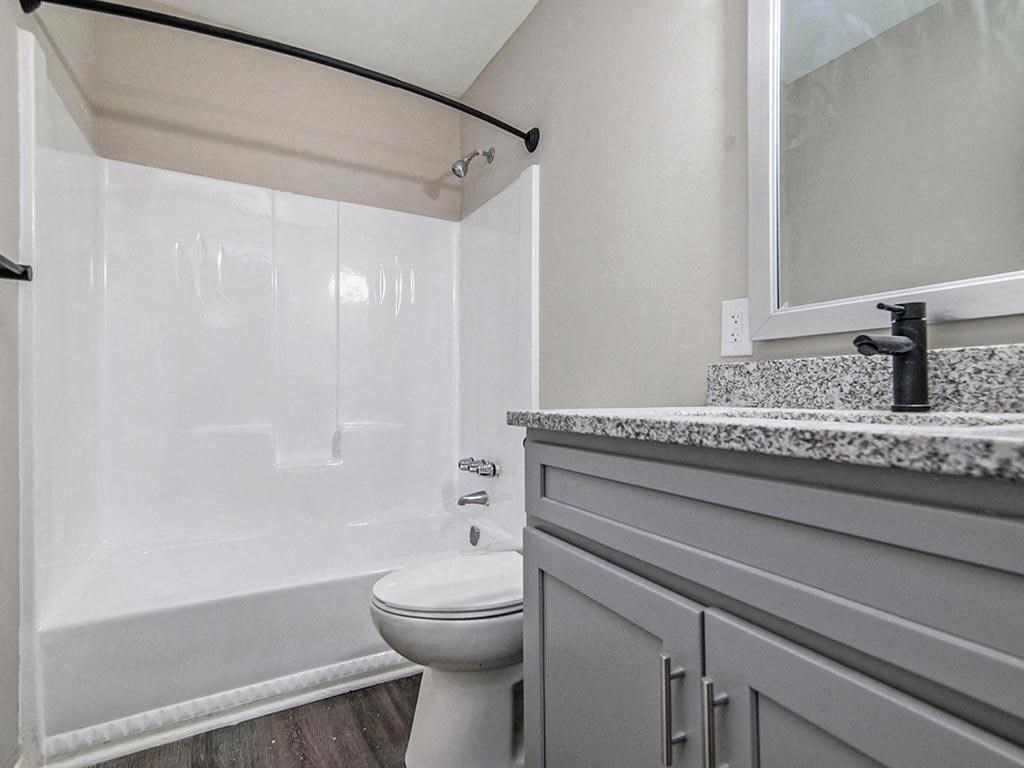 a bathroom with a toilet and a sink and a shower