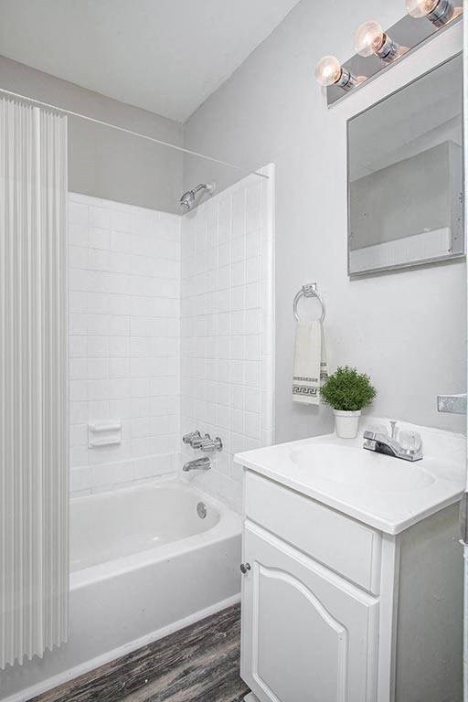 a white bathroom with a tub and a sink