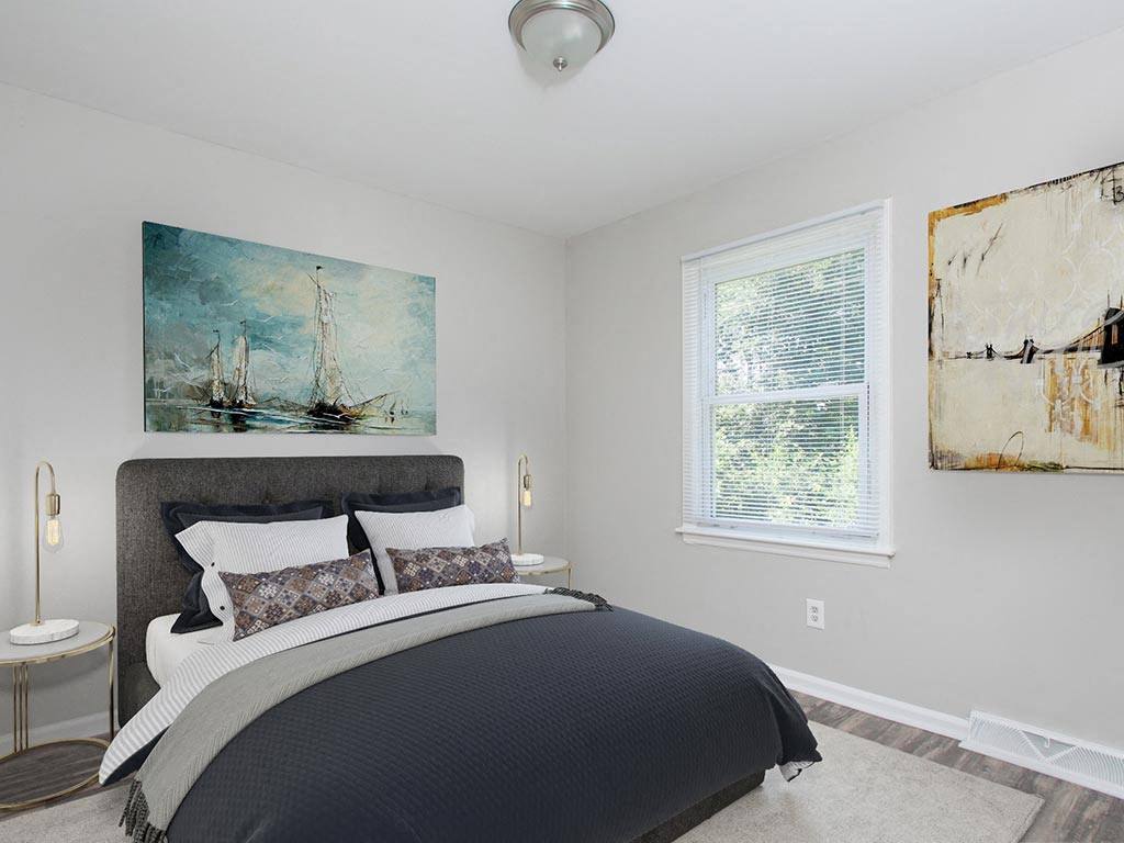 a bedroom with a bed and two windows