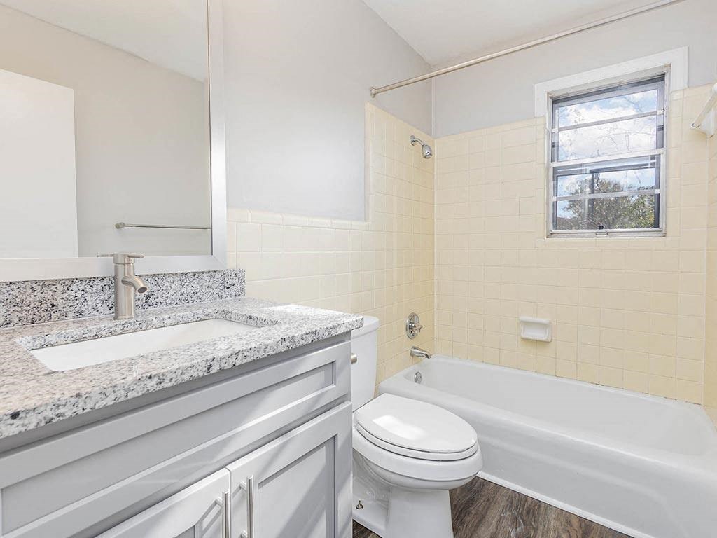a white bathroom with a toilet and a tub