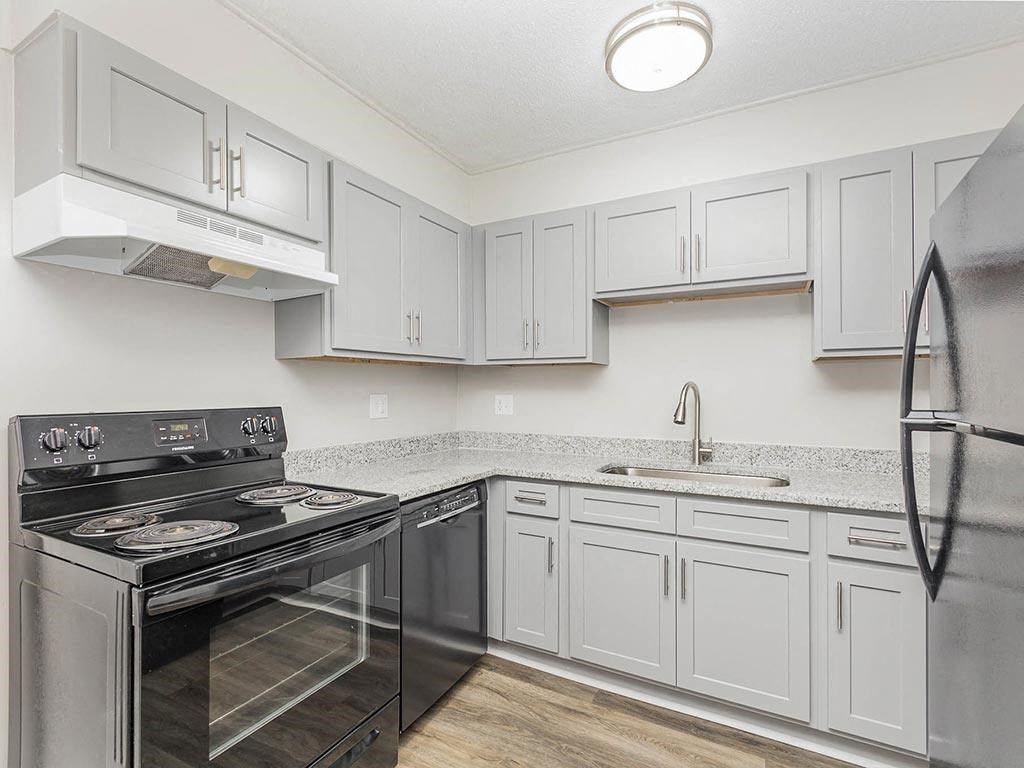 a kitchen with white cabinets and stainless steel appliances