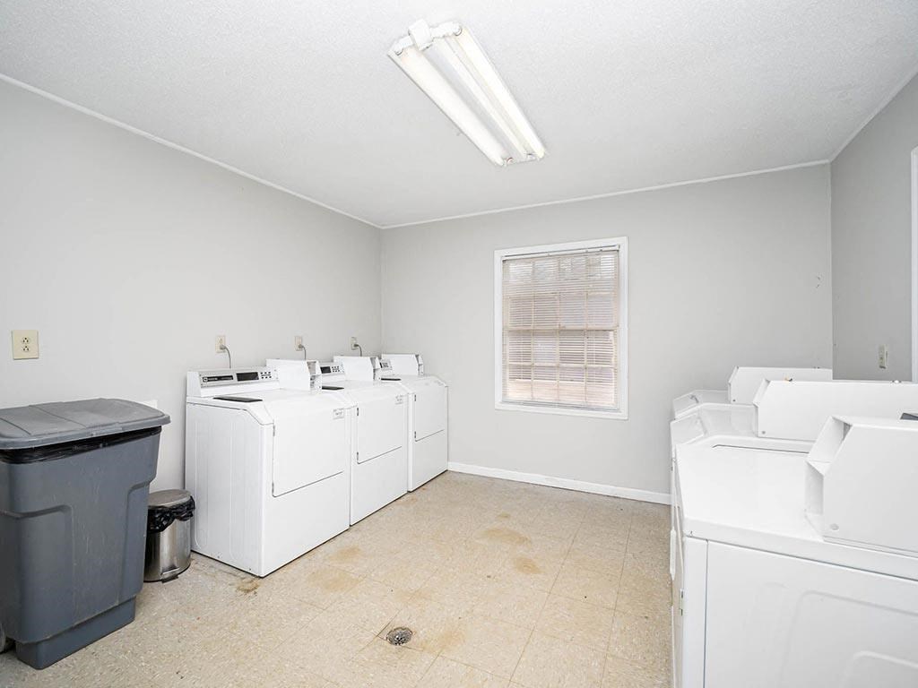 a laundry room with washer and dryers and a window
