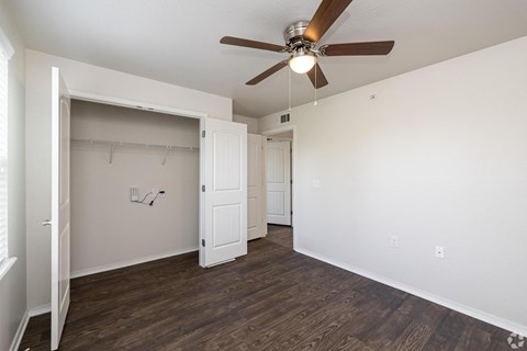 A room with a ceiling fan and wooden floors.