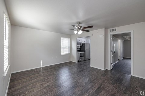A room with a ceiling fan and wooden flooring.